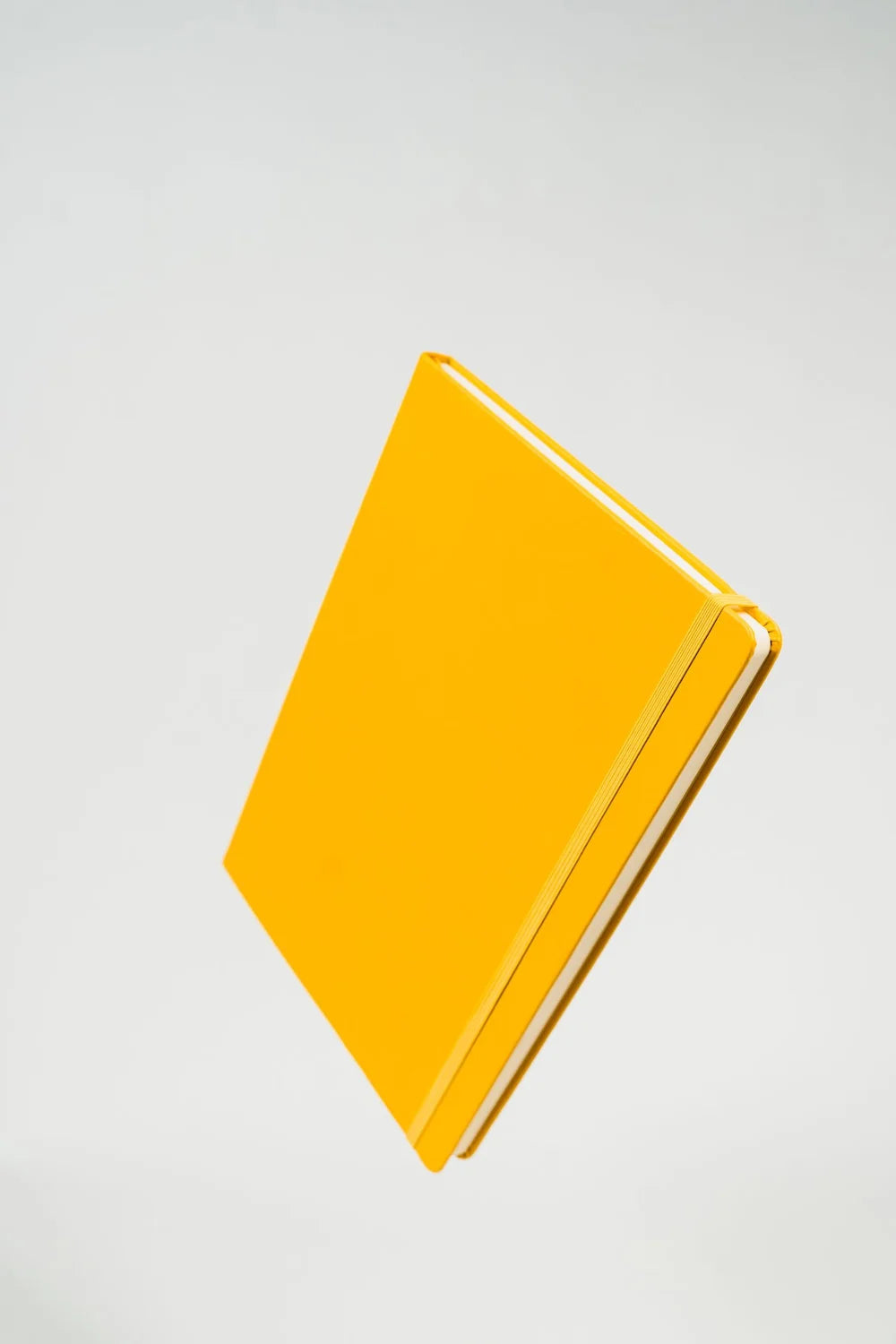 Yellow Outside the Box Notebook floating on a pale background