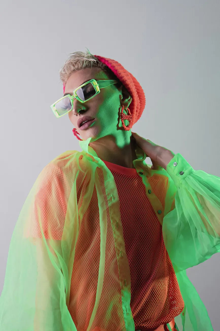 Woman in pink and green with white sunglasses